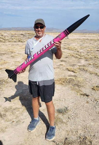 A picture of the President Mark holding a very large rocket.